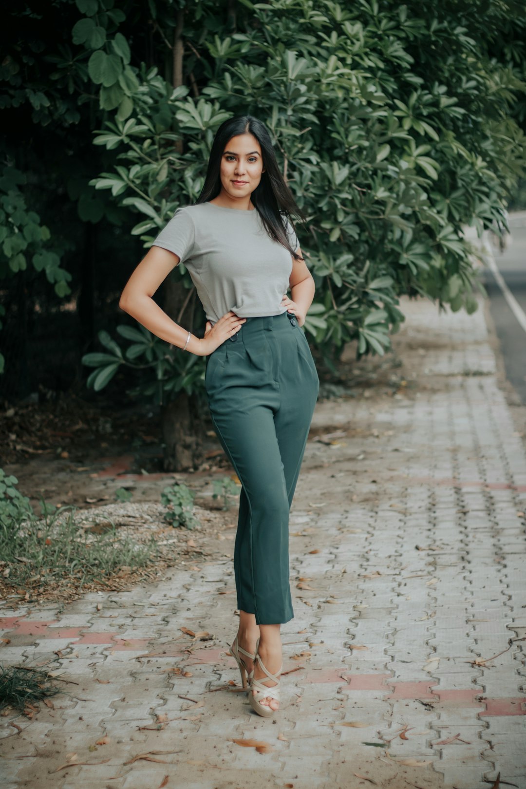 woman in white shirt and black pants standing on pathway