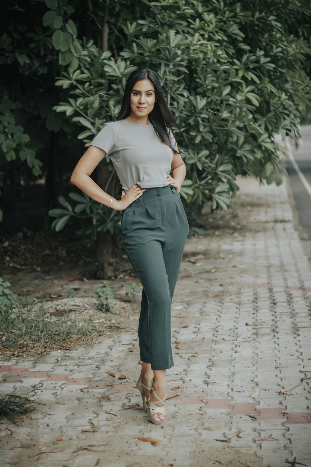 woman in white shirt and black pants standing on pathway