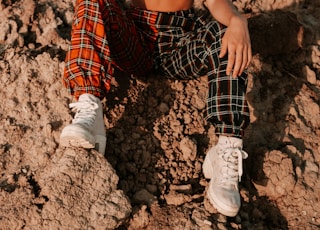 woman in white tank top and black red and white plaid skirt wearing sunglasses