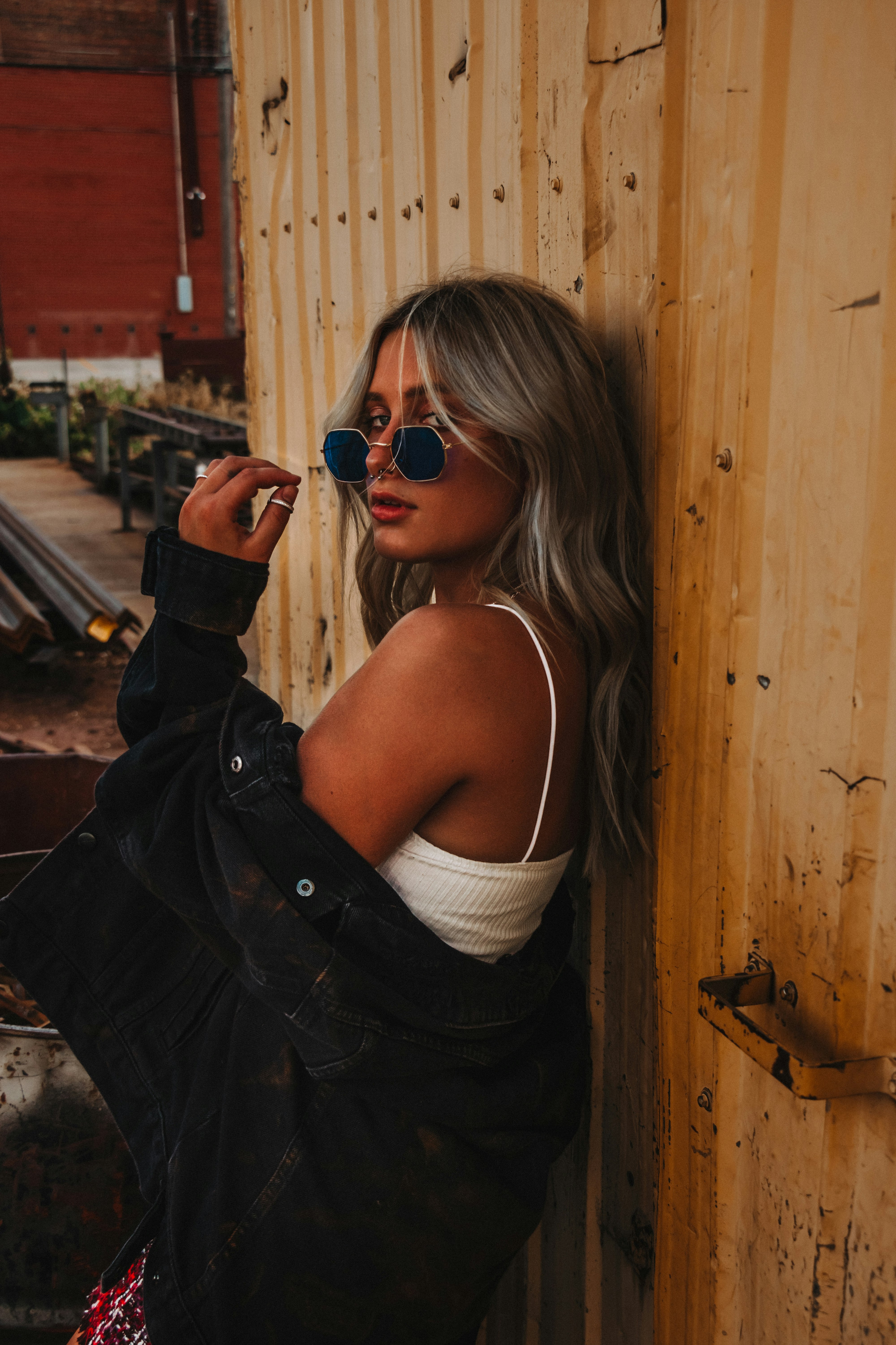 woman in white tank top and black jacket wearing black sunglasses