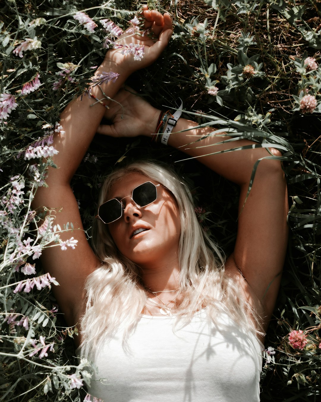 woman in white shirt lying on purple flowers