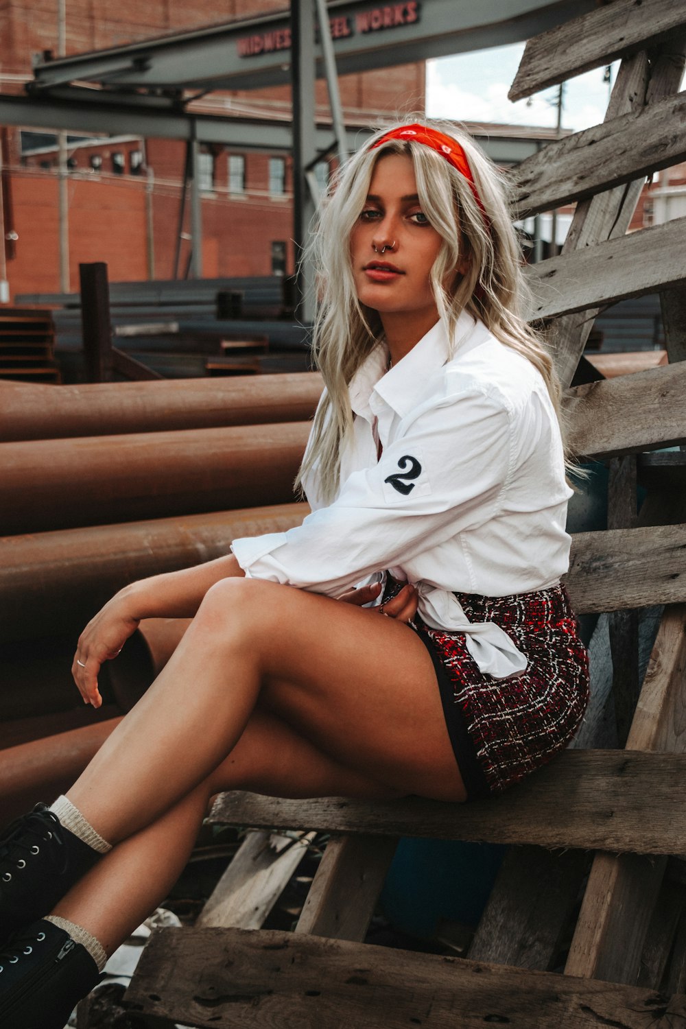 woman in white polo shirt sitting on brown wooden bench