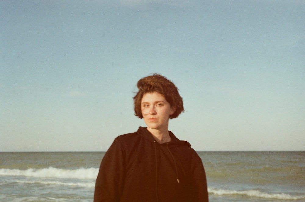 woman in brown long sleeve shirt standing on beach during daytime