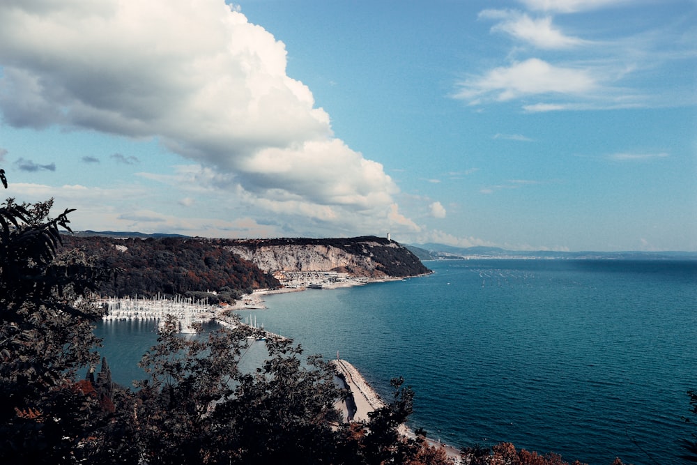 body of water near mountain under blue sky during daytime