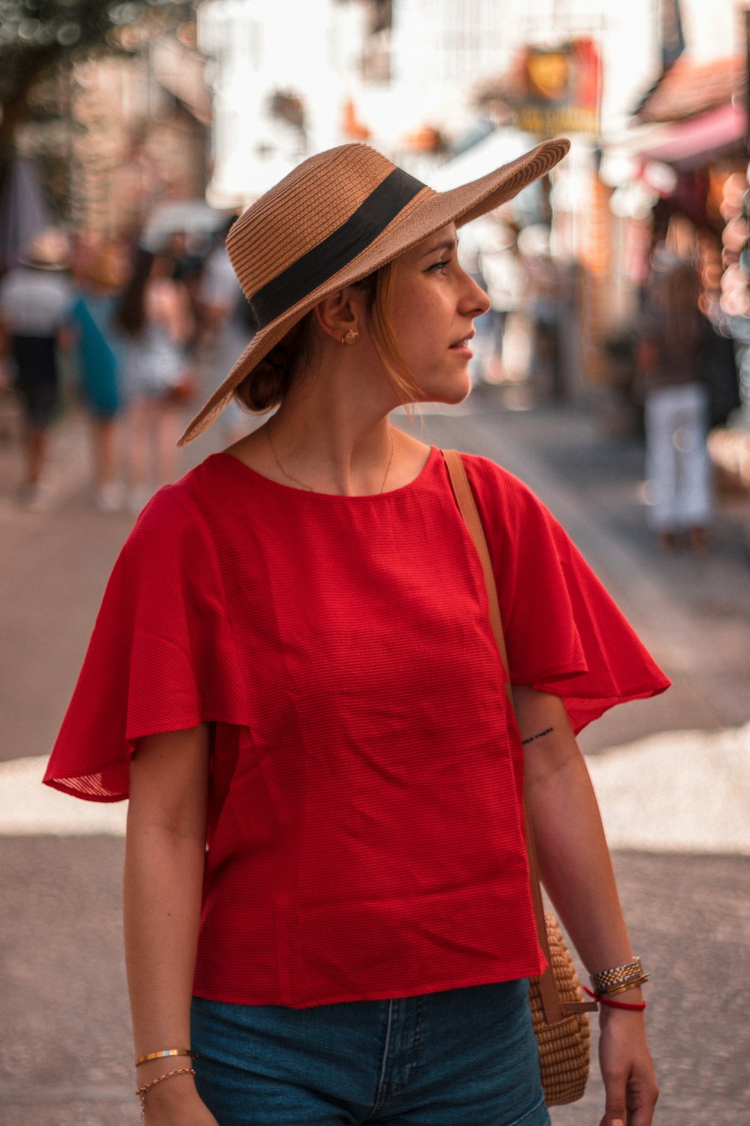 woman in red crew neck t-shirt wearing brown fedora hat