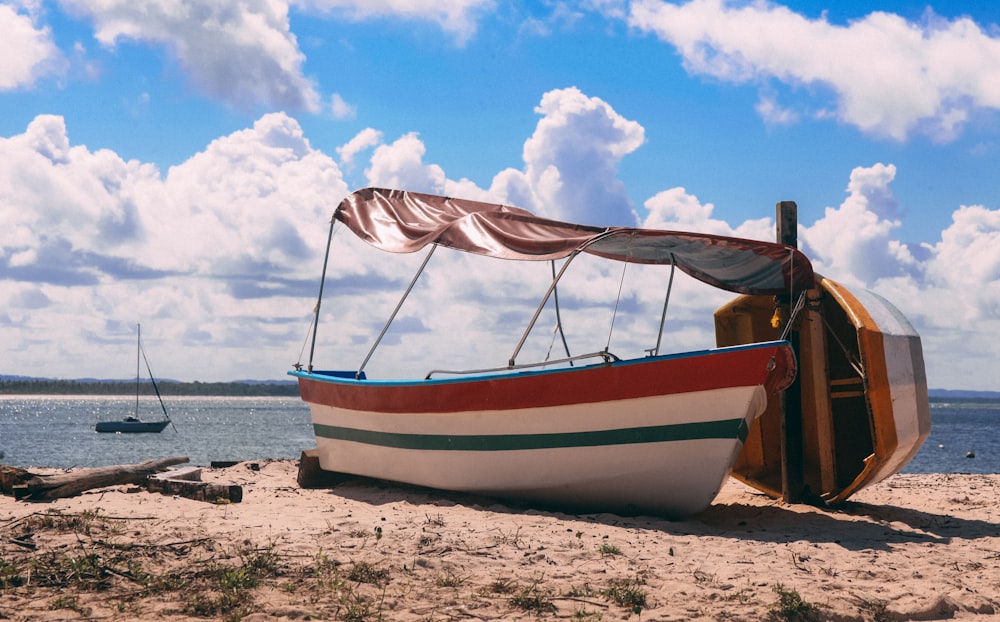 white and brown boat on beach during daytime