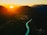 Aerial shot of a lush Ecuadorian landscape with mountains and rivers at sunset.