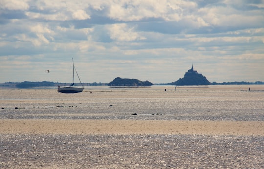 white boat on sea shore during daytime in Baie du Mont-Saint-Michel France