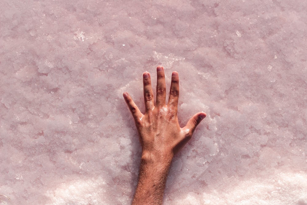 persons left hand on gray concrete floor