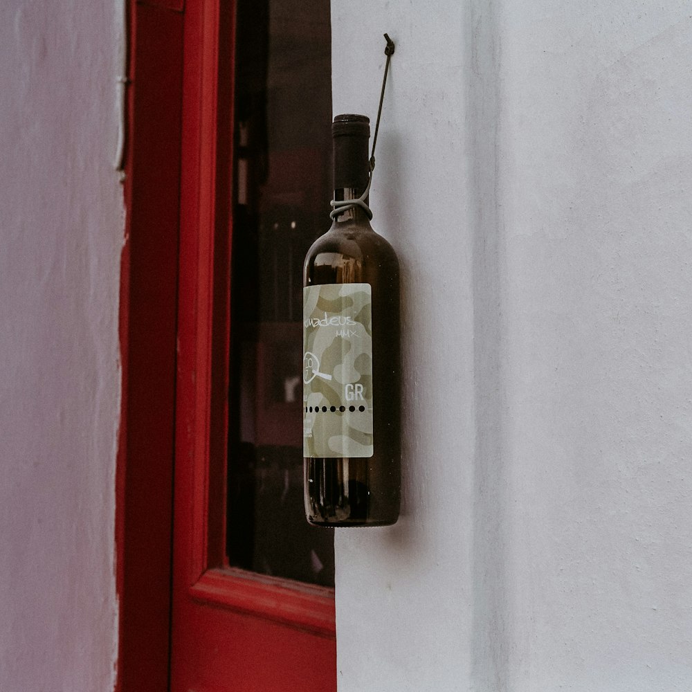 black glass bottle on red wooden window