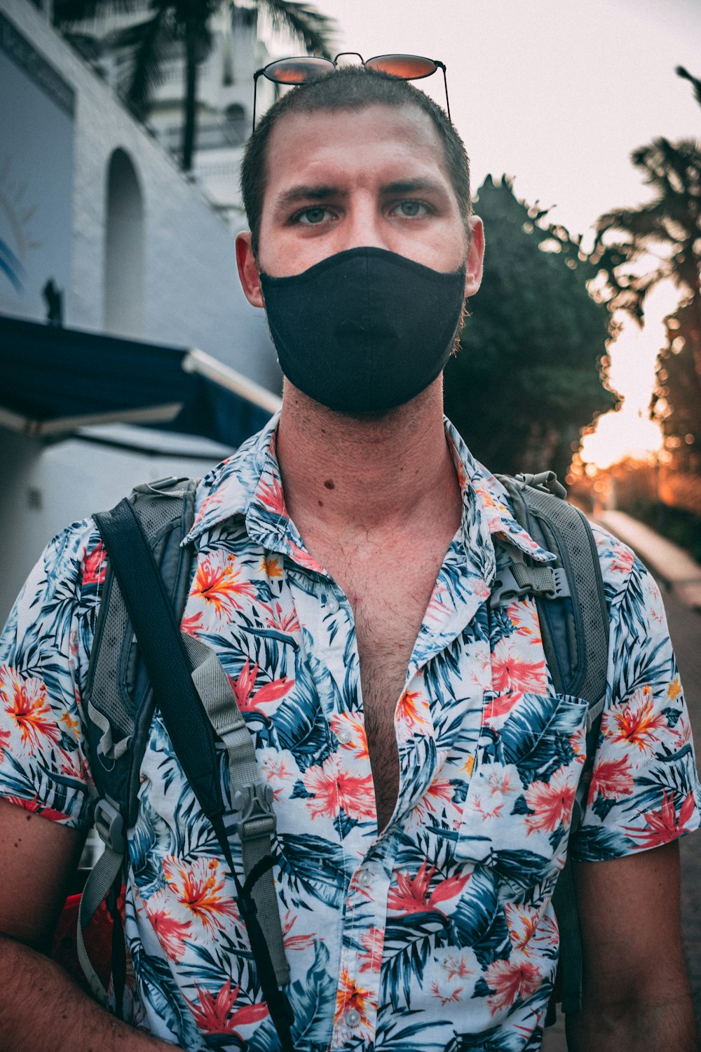 man in white blue and red floral button up shirt wearing black mask