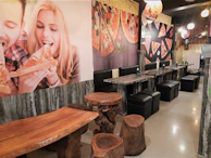 Happy guests enjoying their pizza plates in the cozy, inviting atmosphere of Sabor Cielo.