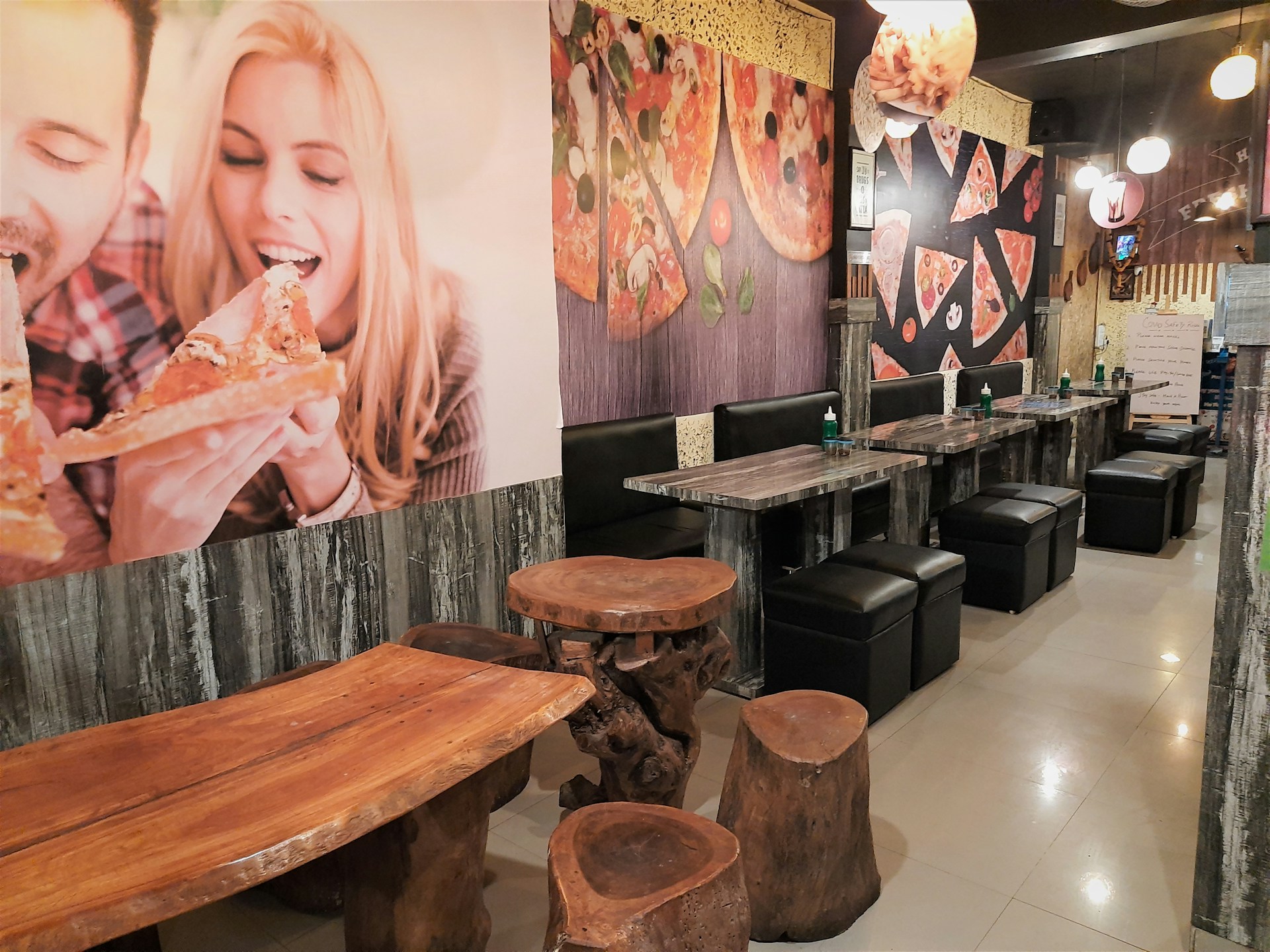 A cozy dining area with wooden tables, soft lighting, and red and green accents reflecting the Italian color palette, filled with happy families enjoying their meals.