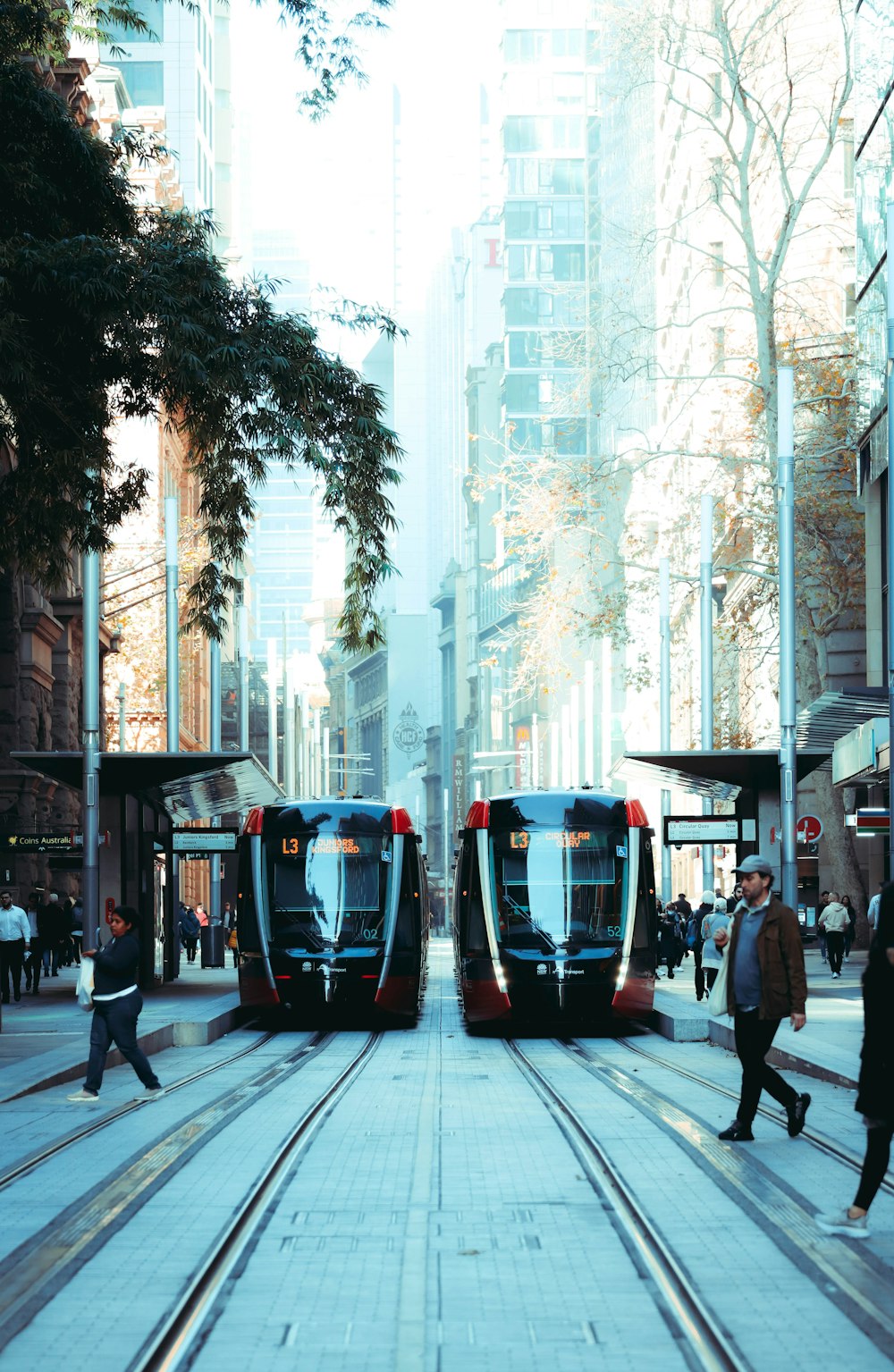 people walking on sidewalk near cars on road during daytime