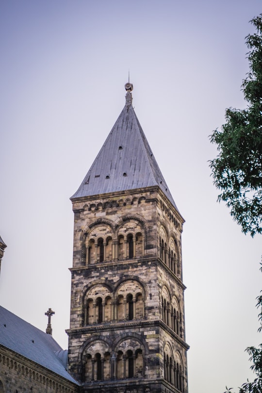 brown concrete building under white sky during daytime in Lund Cathedral Sweden