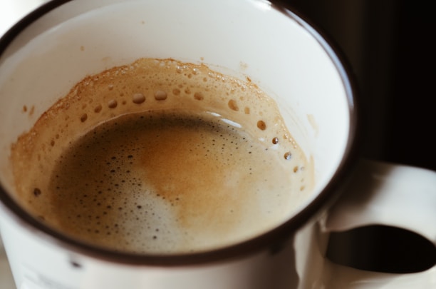 Close-up of a steaming cup of South Indian filter coffee with a rich crema on top.