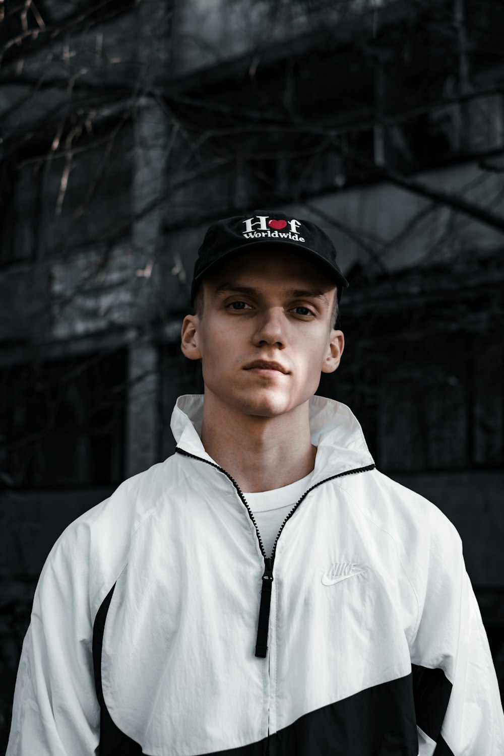 man in white zip up jacket wearing black cap