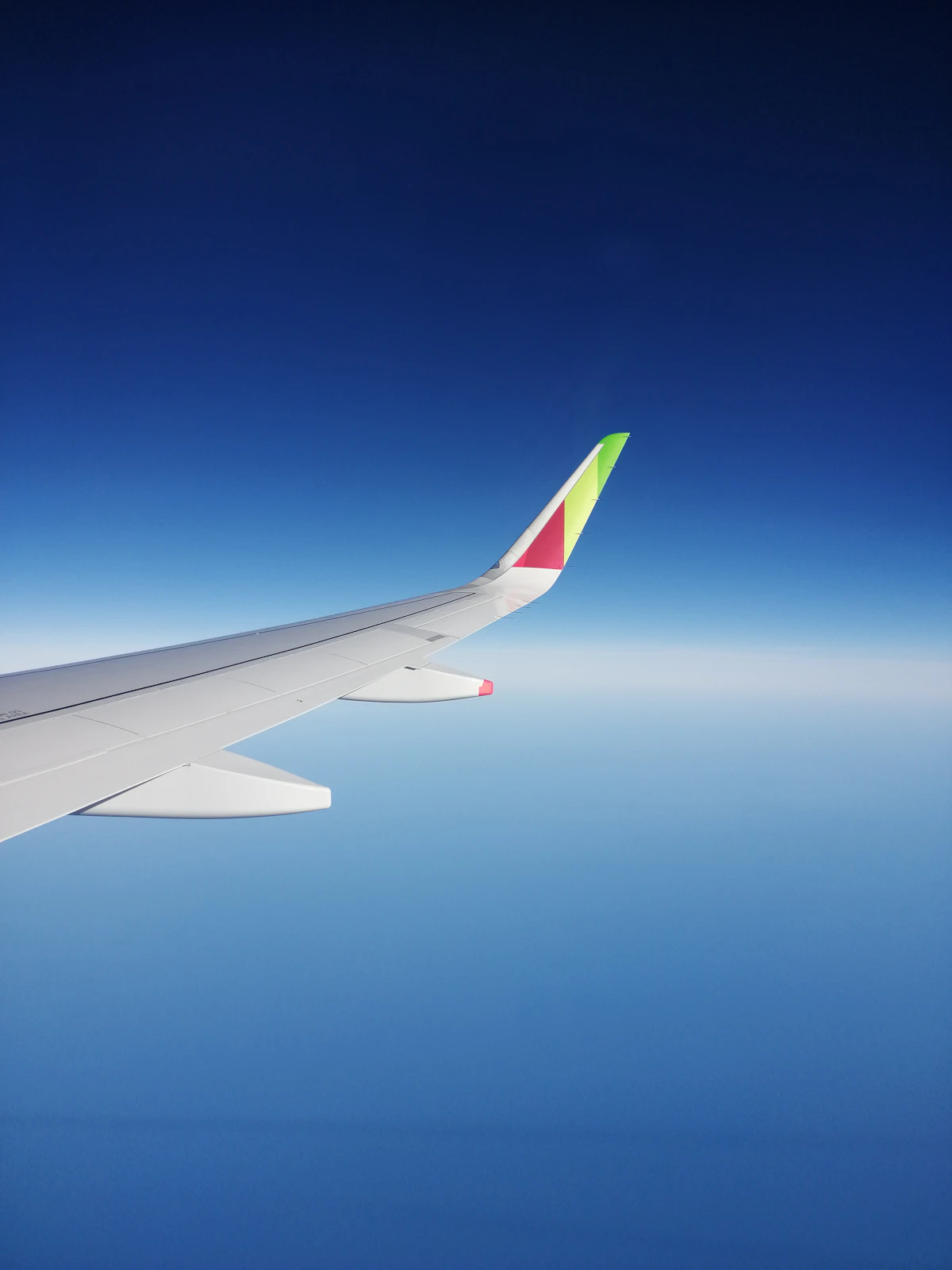 Airplane wing above clouds at sunset