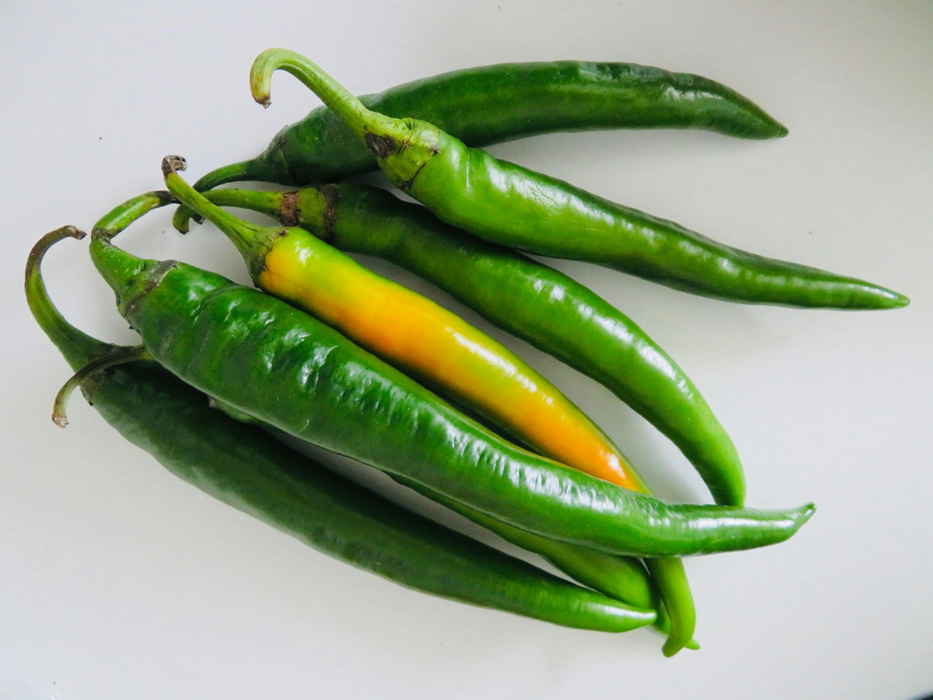 green chili on white surface