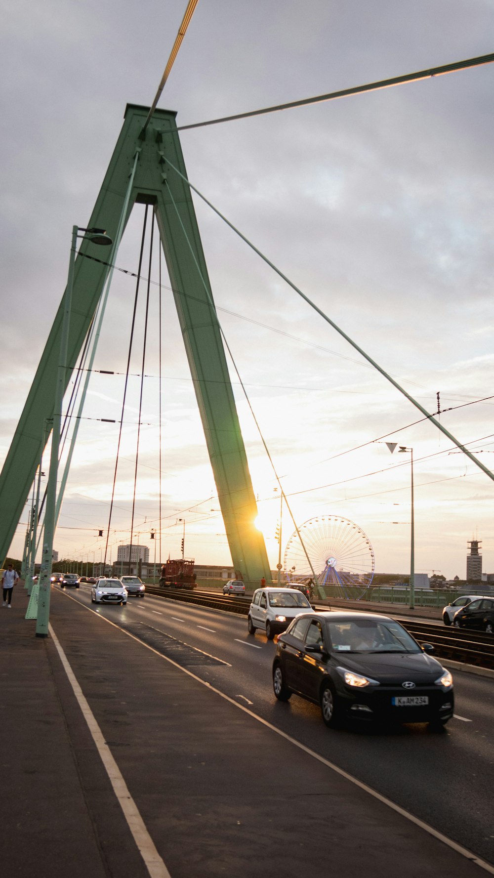 a car driving on a road with a bridge in the background