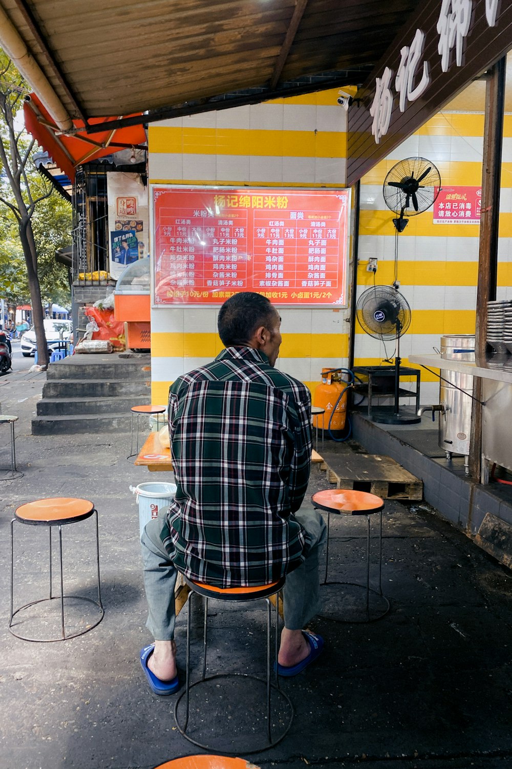 man in blue and white plaid dress shirt sitting on chair