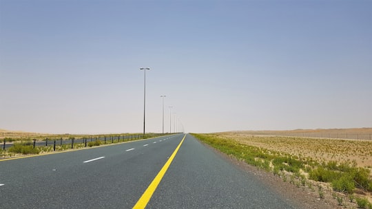 gray concrete road under blue sky during daytime in Al Dhafra - Abu Dhabi - United Arab Emirates United Arab Emirates
