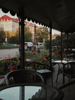 A discreet private detective observing a subject from a shaded café terrace in a bustling French city.
