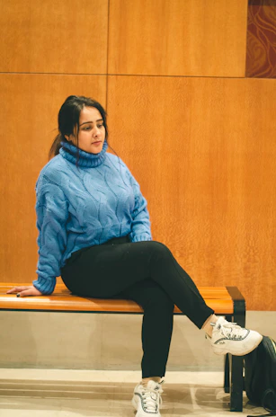 A cozy knit sweater paired with wide-leg trousers on a wooden bench.