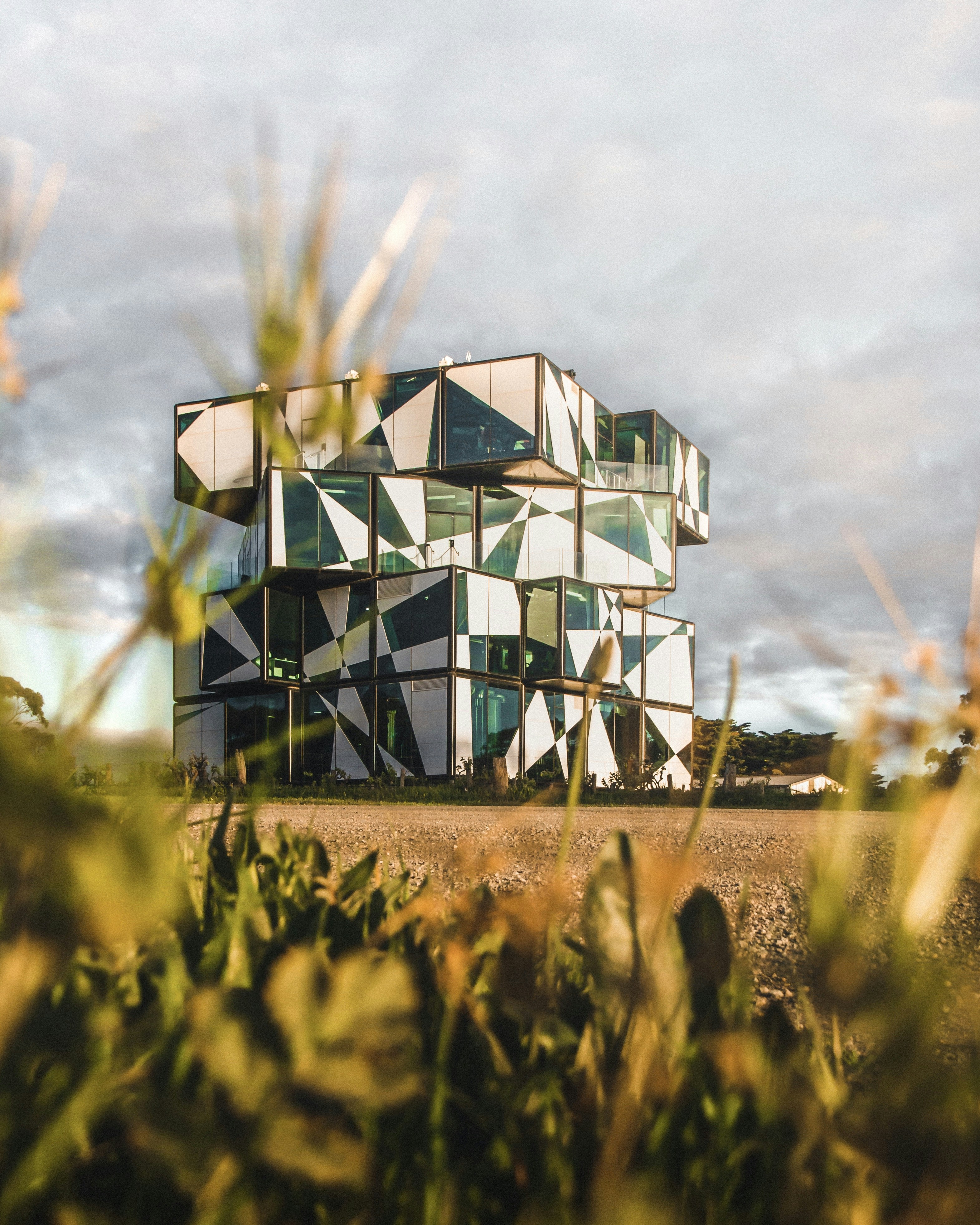 green and black wooden house on brown field under white clouds and blue sky during daytime