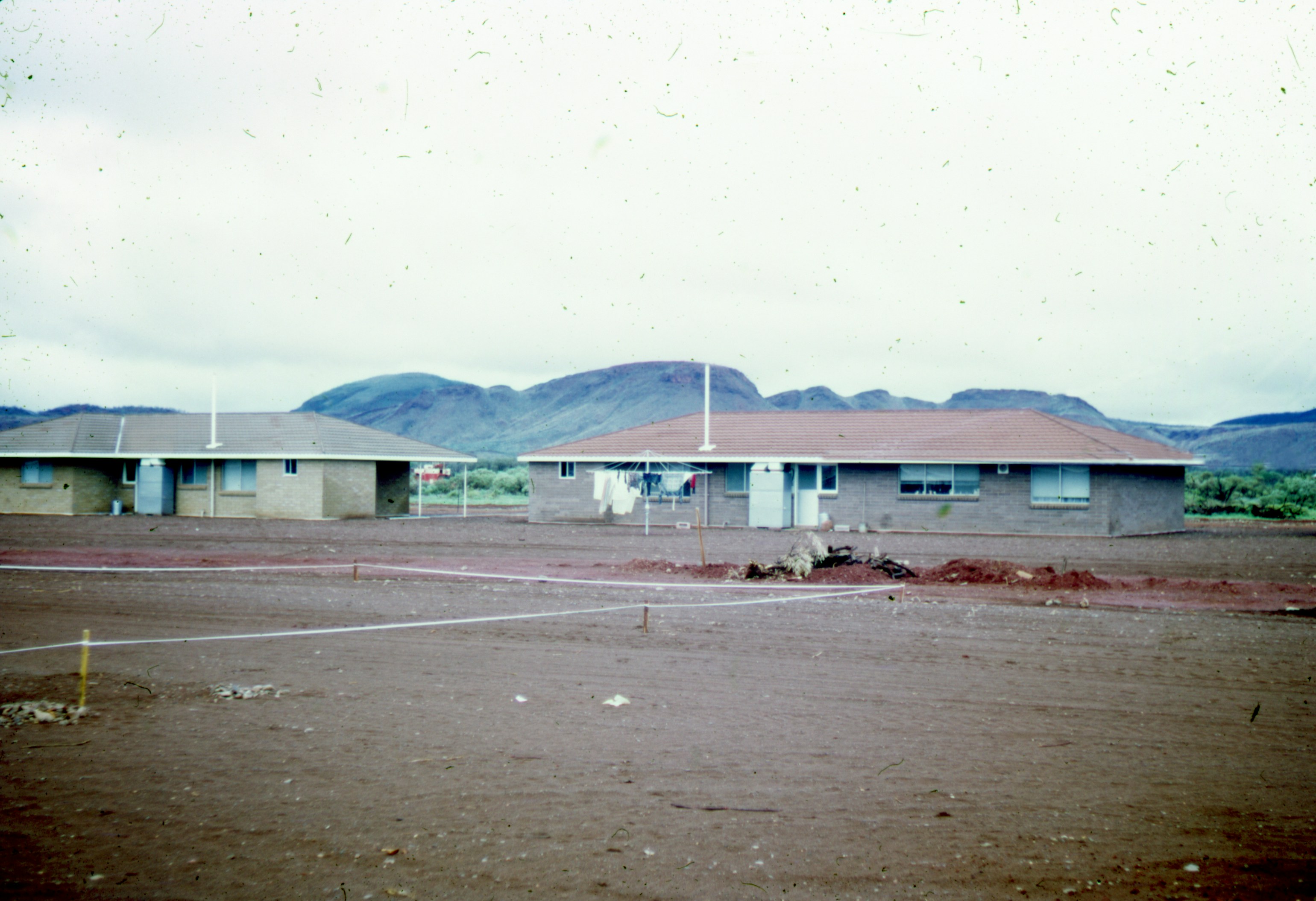 white and brown building near green mountain during daytime