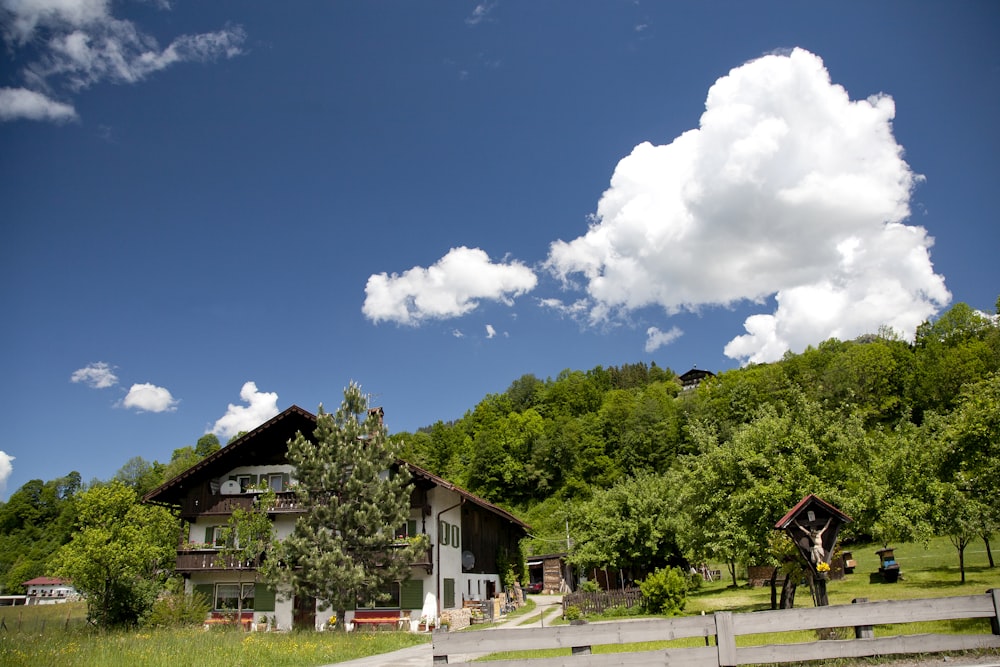 a large house sitting on top of a lush green hillside