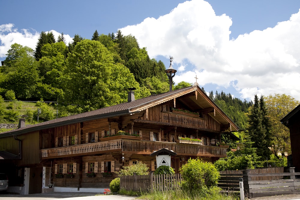 brown wooden house surrounded by green trees under blue sky during daytime