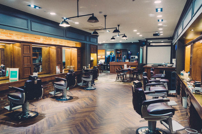 Upscale barbershop interior with teal wood paneling and warm brass fixtures