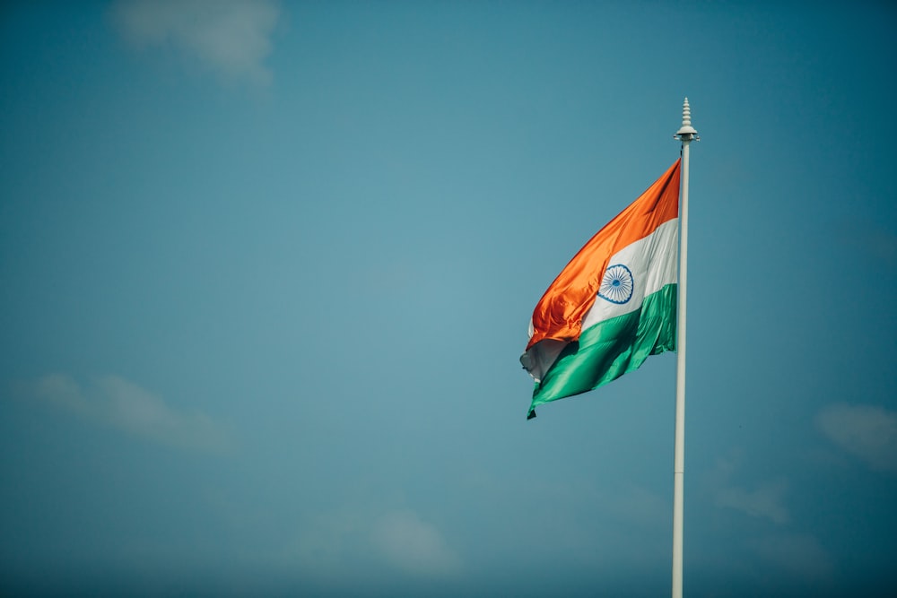 orange white and green flag under blue sky during daytime