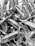 A collection of cylindrical objects wrapped tightly in plastic or some reflective material. They appear to be tied at the ends, creating a sealed package look. The image is in black and white.