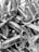 A collection of cylindrical objects wrapped tightly in plastic or some reflective material. They appear to be tied at the ends, creating a sealed package look. The image is in black and white.