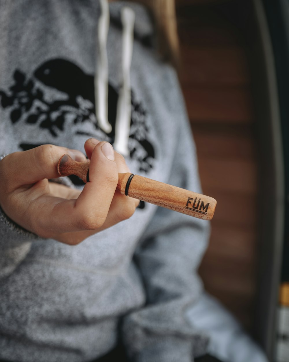 person holding brown wooden rolling pin