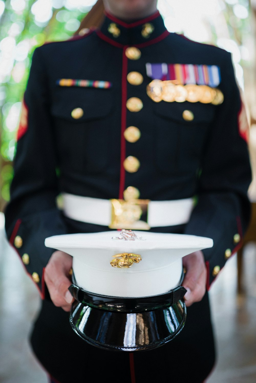 Person in schwarz-weißer Uniform hält weiße Keramikschale mit Essen