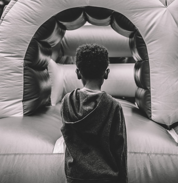 boy in gray sweater sitting on gray leather couch