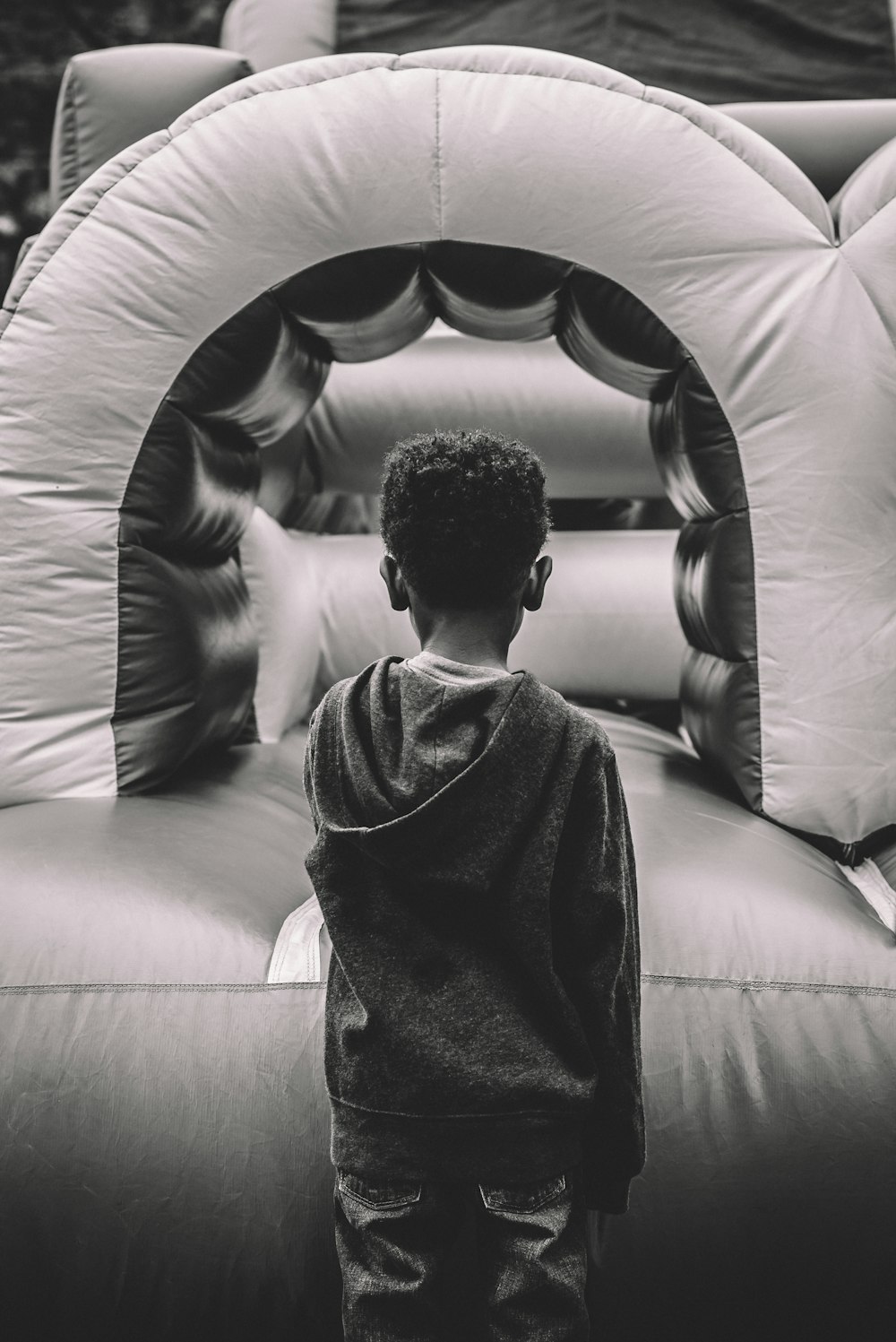 boy in gray sweater sitting on gray leather couch