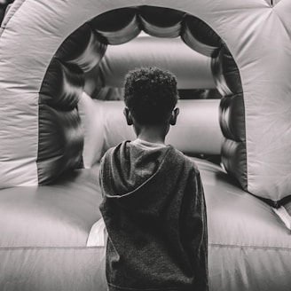 boy in gray sweater sitting on gray leather couch