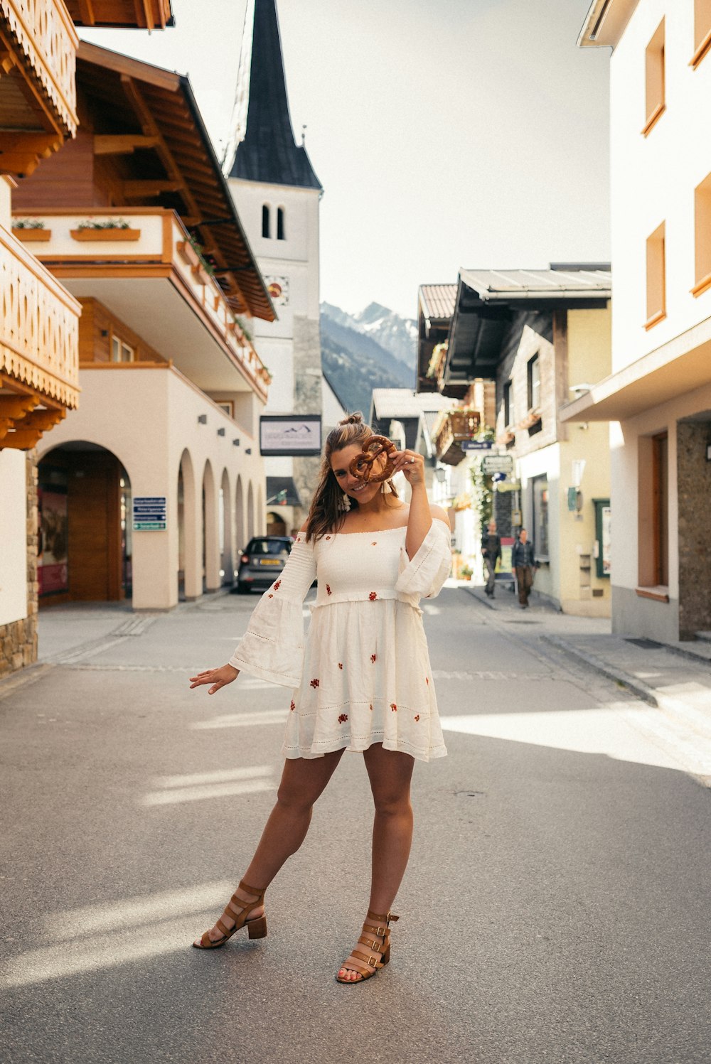 Femme en robe blanche debout dans la rue pendant la journée
