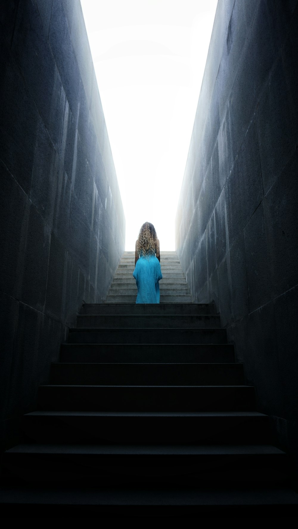 Mujer en vestido azul caminando por las escaleras
