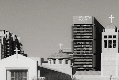 A Houston cityscape in black and white with a mobile testing van parked outside a business.
