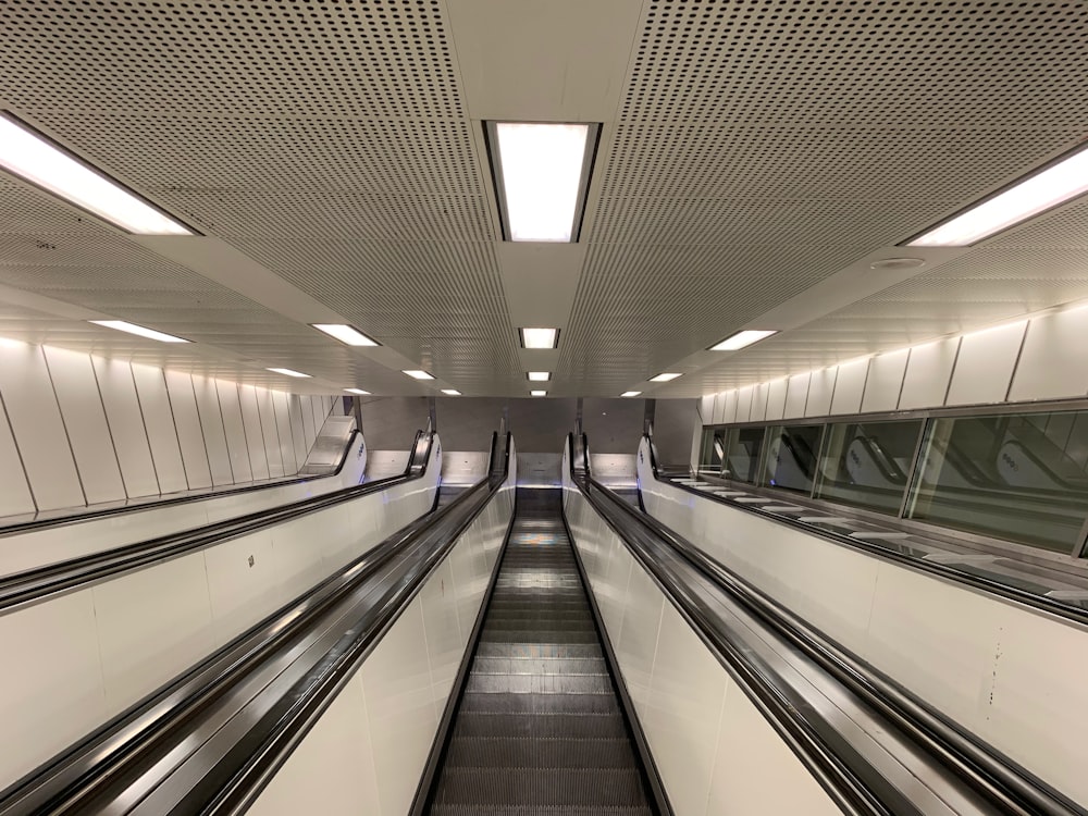 Personas caminando por las escaleras mecánicas dentro del edificio