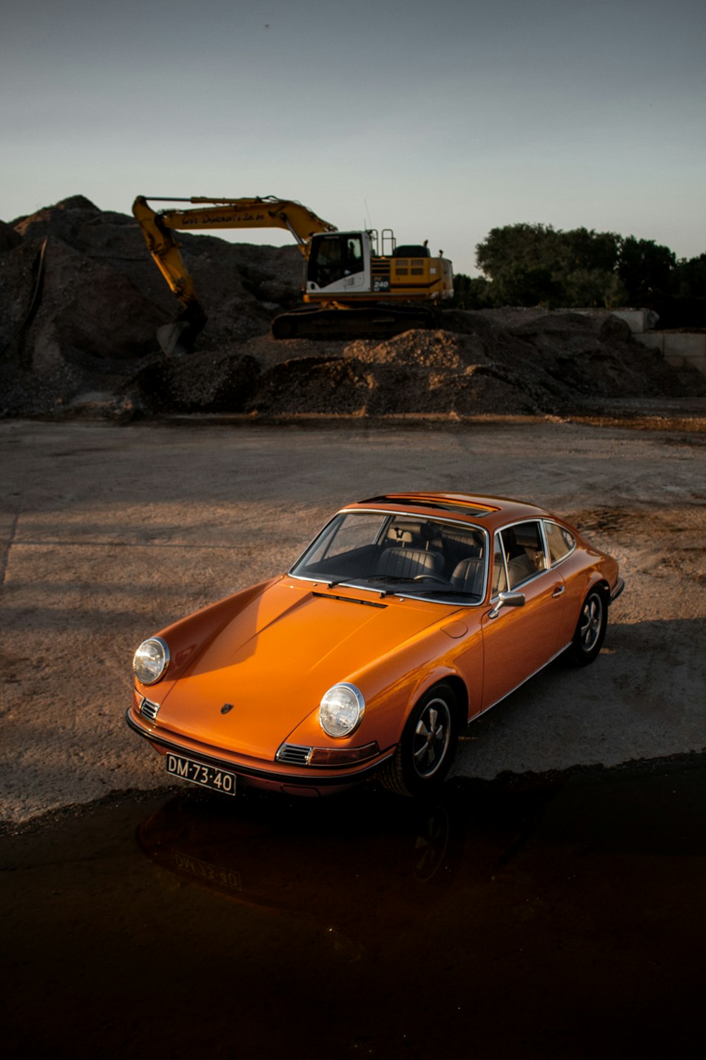 orange-schwarzes Coupé auf braunem Sand tagsüber