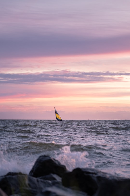 person surfing on sea waves during sunset in Makkum Netherlands