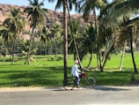 man in white shirt riding bicycle on road during daytime
