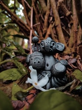 2 gray owl figurines on brown tree trunk