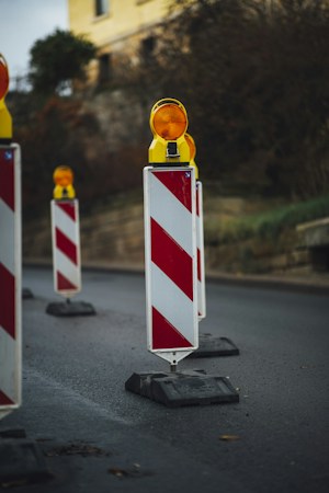 Red and white striped traffic barrier marking a closed lane on a roadway